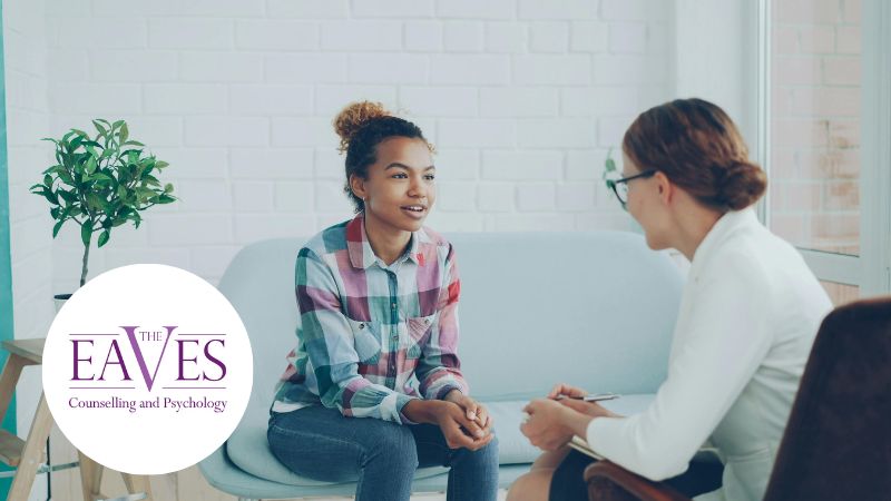 Person in a therapy session speaking with a mental health therapist in a calm, private setting