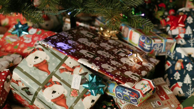 Wrapped Christmas presents under a decorated tree, representing the festive season and thoughtful gift-giving