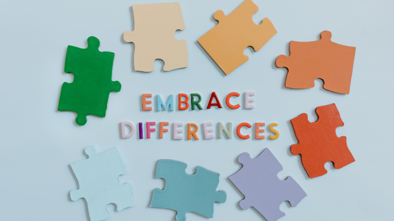 Colourful puzzle pieces in green, orange, purple, and blue forming the words “Embrace Difference,” symbolising diversity and inclusivity in mental health.