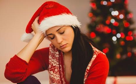 Lonely Woman with Santa's Hat at Christmas whilst having Head in Hands