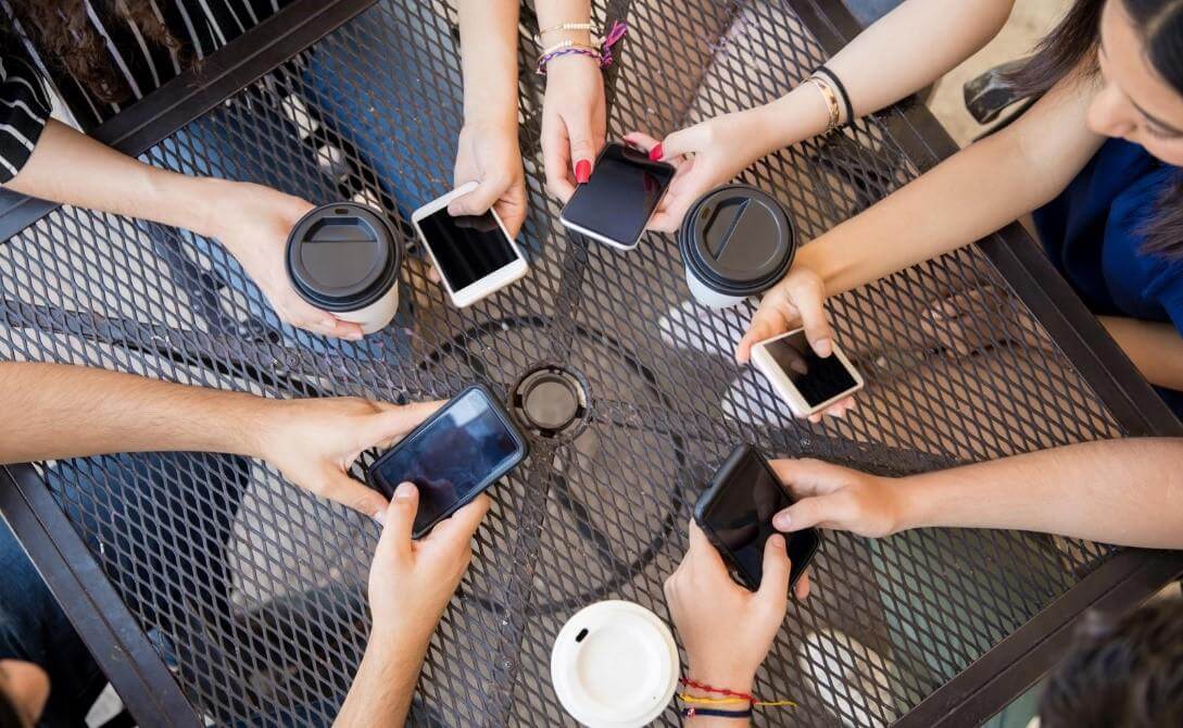 Group of Friends with Phones and Coffee on Table