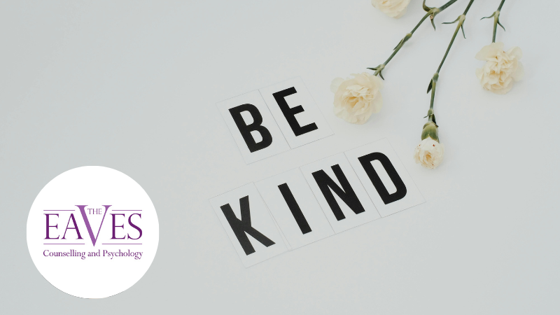 Letters spelling “Be kind” with white flowers in the top right corner.