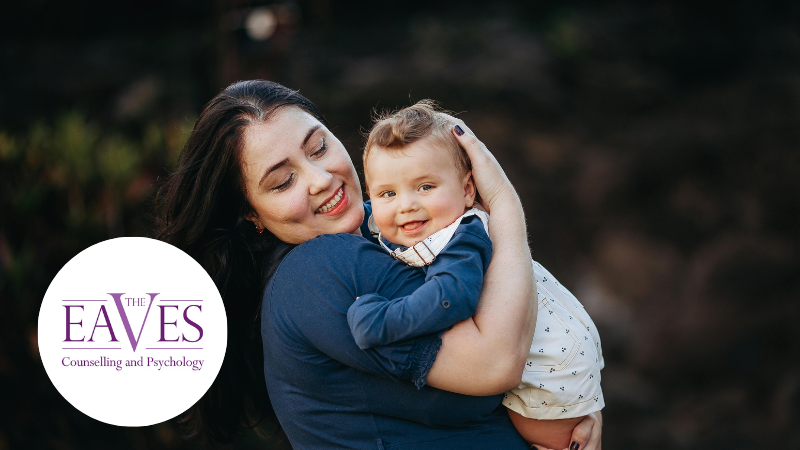 Mother smiling while holding her baby, representing maternal mental health and emotional wellbeing – The Eaves Counselling and Psychology