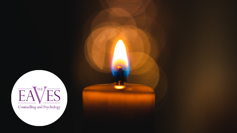 A single candle burning in the darkness, symbolising grief, remembrance and hope after loss