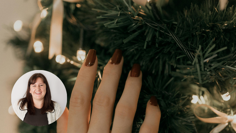 Christmas tree being decorated with gold ribbons by a hand with red nails, representing avoiding relationship strain during the holidays