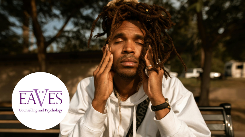 Stress Awareness Day image showing an adult man sitting on a park bench with his eyes closed and his hands on his face, representing stress, overwhelm, and the need for emotional support