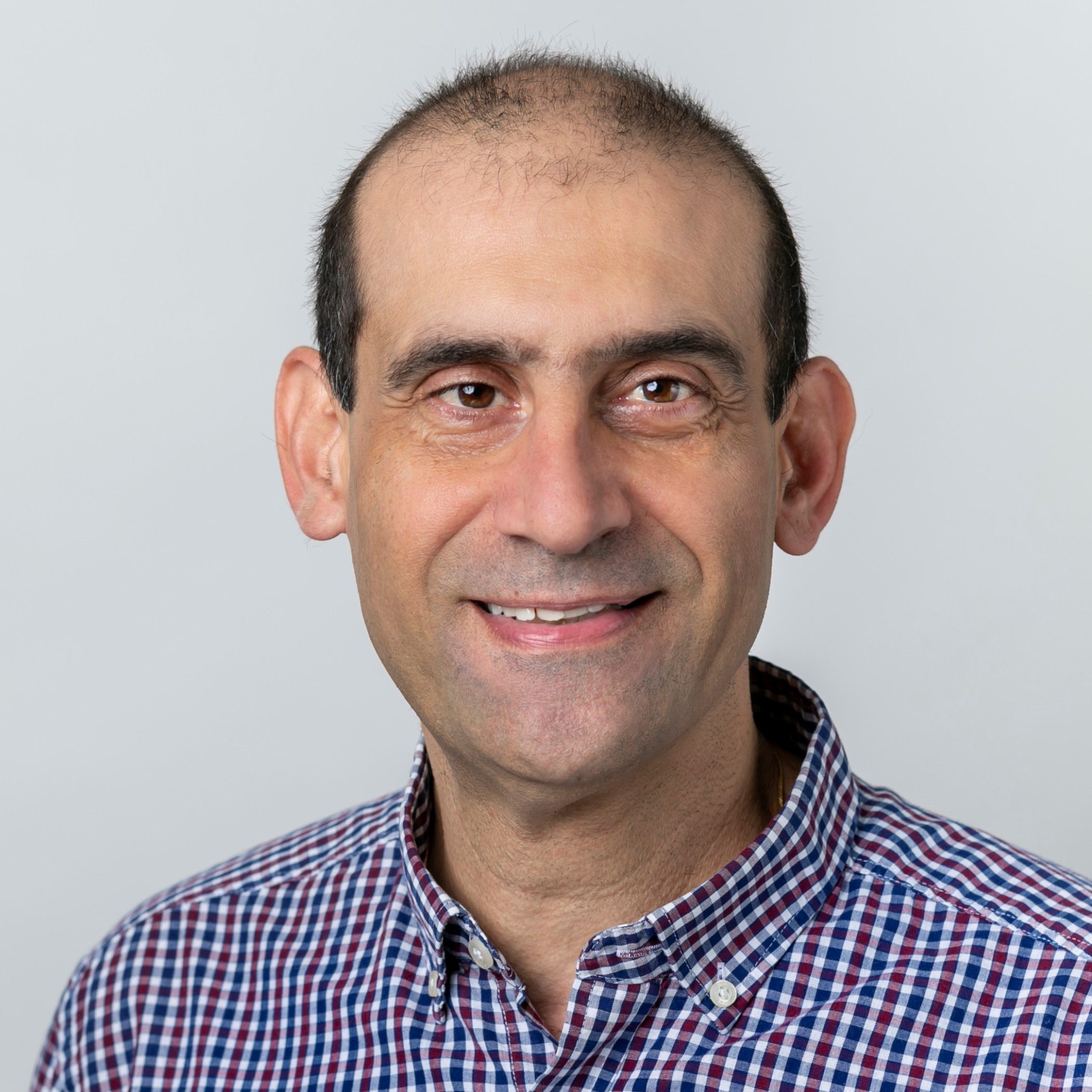 Claude Distefano, BACP and BABCP accredited CBT psychotherapist wearing purple and white chequered shirt.