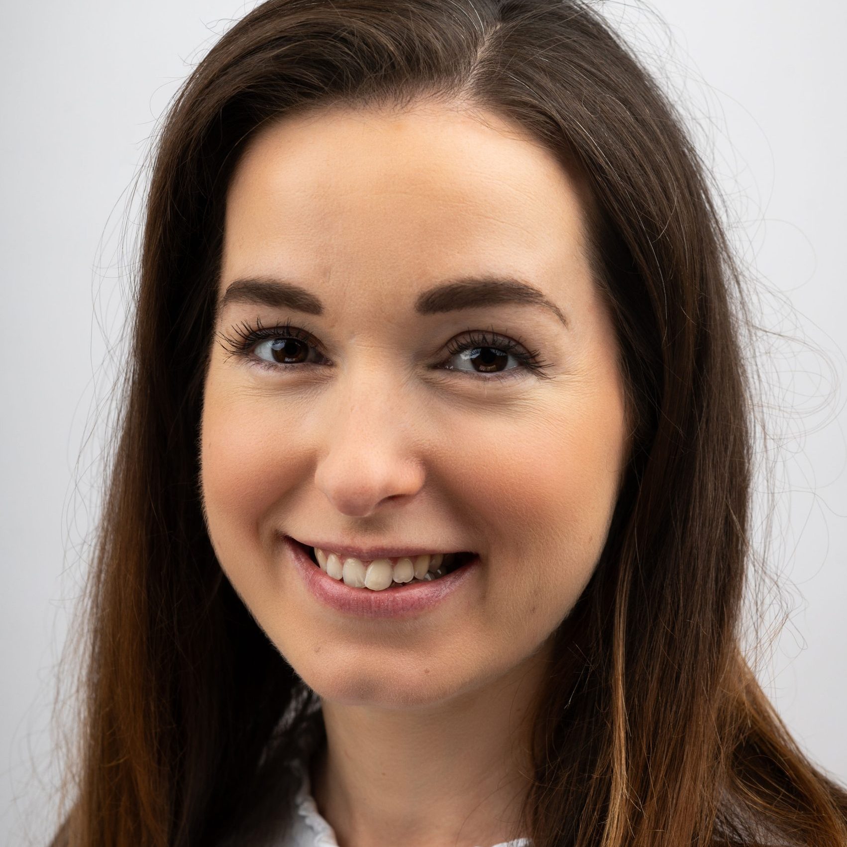 Image of Dr Emma Cosham, clinical psychologist specialising in body image and trauma, a woman with dark brown hair against a white background.