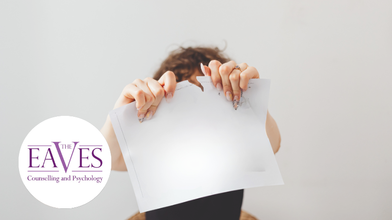 Person tearing a sheet of paper, symbolising the healthy expression of anger, emotional release, and setting personal boundaries.