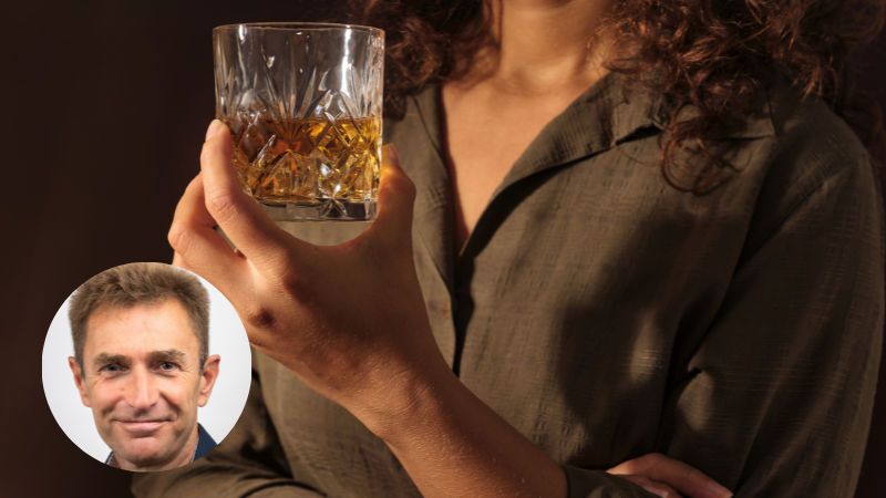 Woman holding a glass of whisky, representing alcohol awareness and mindful drinking