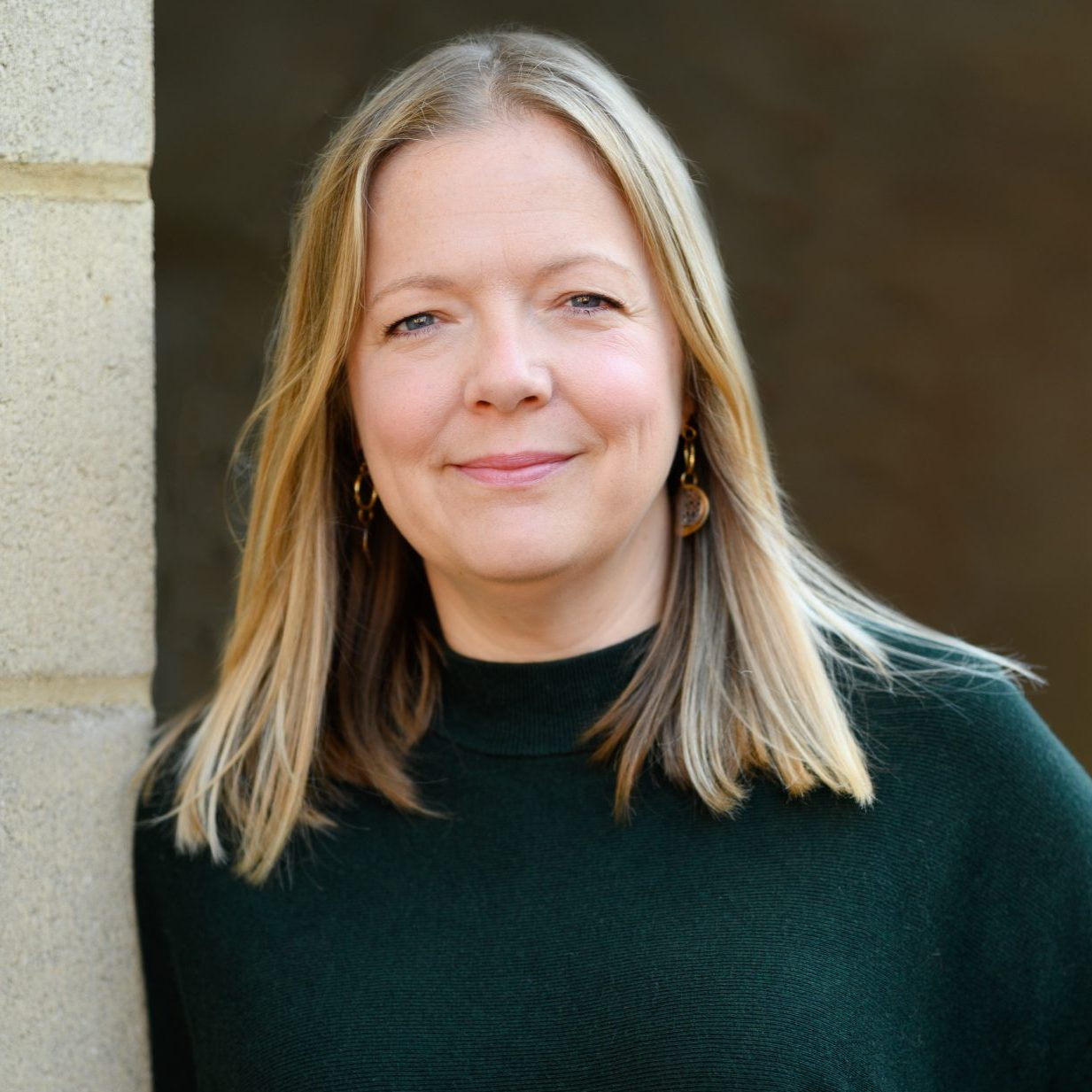 Image of Gemma Midgley, a counsellor and psychotherapist with strawberry blonde hair and a green jumper, supporting clients