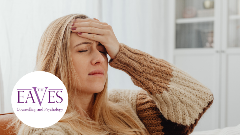 Young woman holding her head in pain, representing the emotional and physical impact of chronic illness.