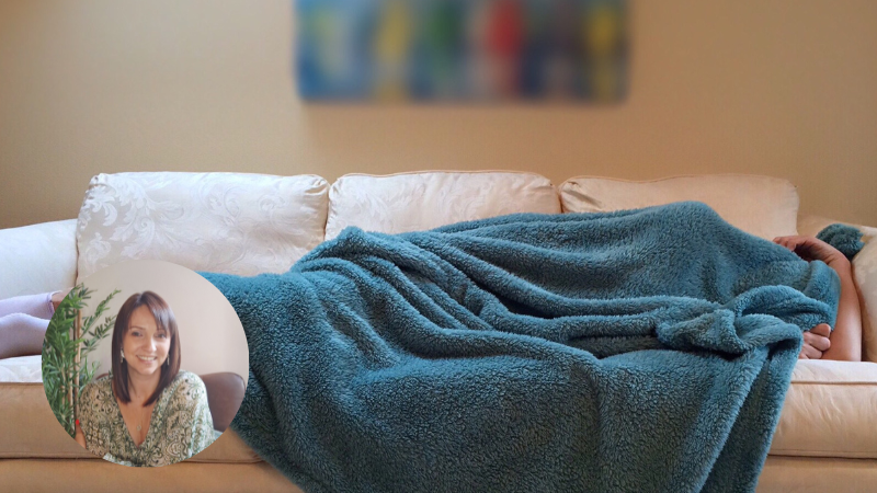 Green fluffy blanket on a cream leather sofa, symbolising rest, comfort and self-compassion.