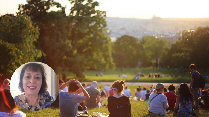 People sitting together on the grass in a sunny park, representing connection, reflection and relationships in mental health.