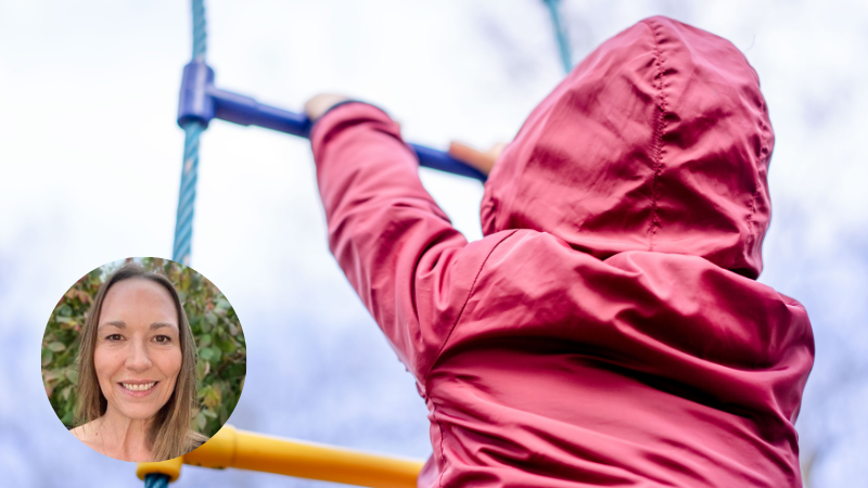 Child wearing a red waterproof coat climbing a rope ladder on a playground, symbolising early development, resilience and childhood experiences.