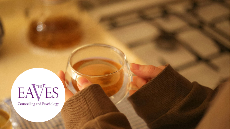 Person holding a clear glass mug of tea, symbolising comfort, connection and emotional support during Brew Monday.