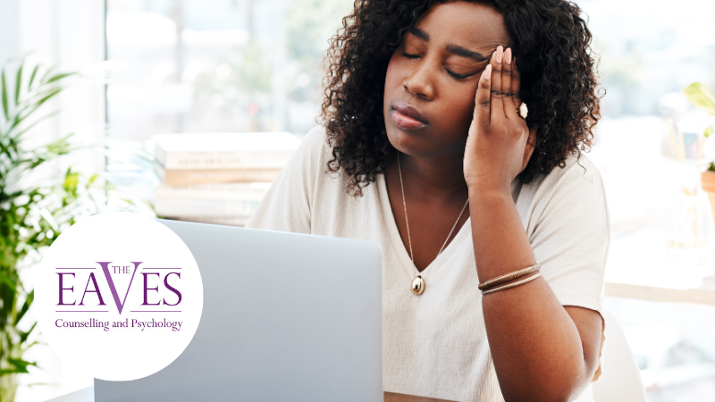 A stressed woman with her head in her hands sitting at a laptop, representing workplace burnout. The Eaves logo is positioned in the bottom left corner alongside the text "Burnout Report Mental Health UK.