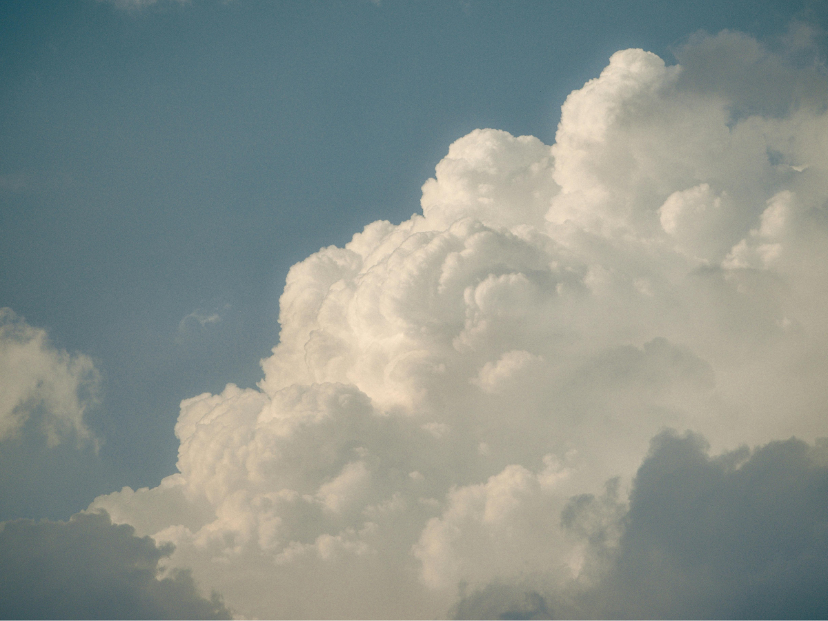 Soft white clouds drifting across a blue sky, symbolising clarity, calm, and perspective