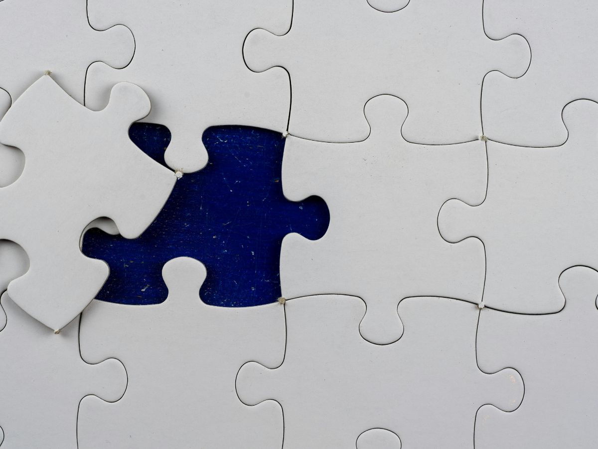 White puzzle on a navy blue background with one piece slightly out of place