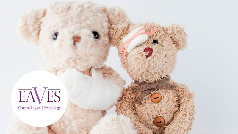 Two teddy bears sit together against a light background. One has a bandaged arm, and the other has a bandaged head and an arm in a sling. The Eaves Counselling and Psychology logo appears in the lower left corner.