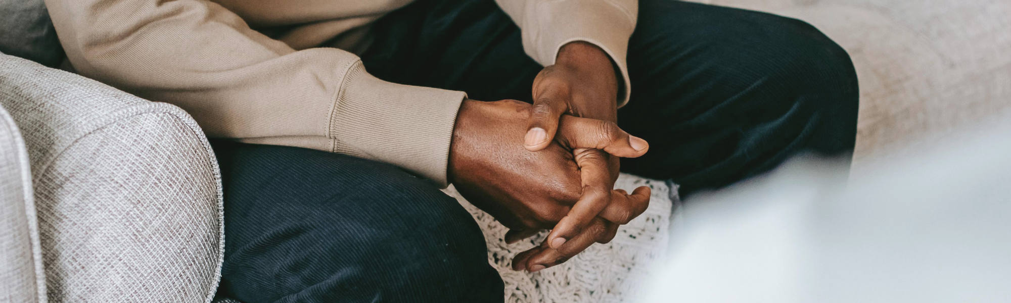 Client sitting with hands in lap during a mental health counselling session, receiving professional support for emotional well-being
