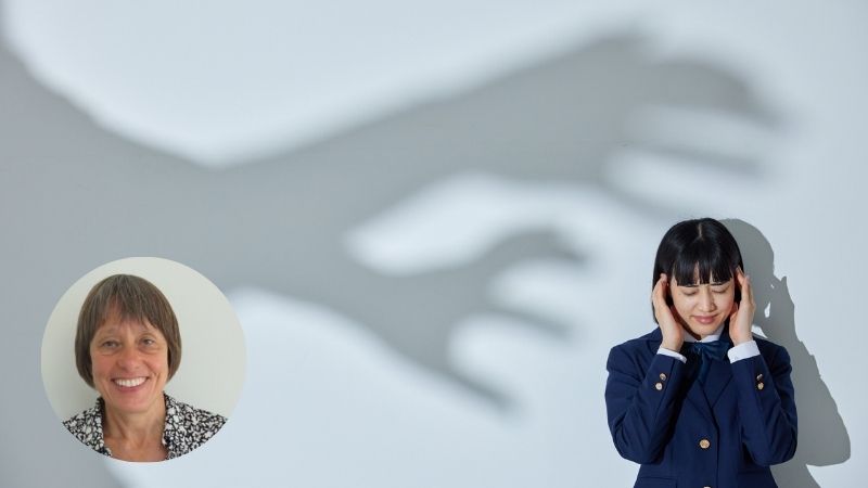 Woman holding her temples with eyes closed, shadowy hands reaching toward her, depicting anxiety and stress