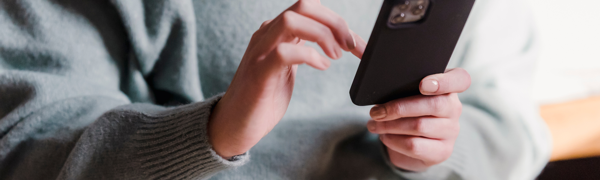 Individual engaged with phone in a moment of reflection