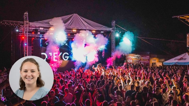 Crowd enjoying a night-time music festival with a brightly lit stage in the background, capturing the energy of a live concert.