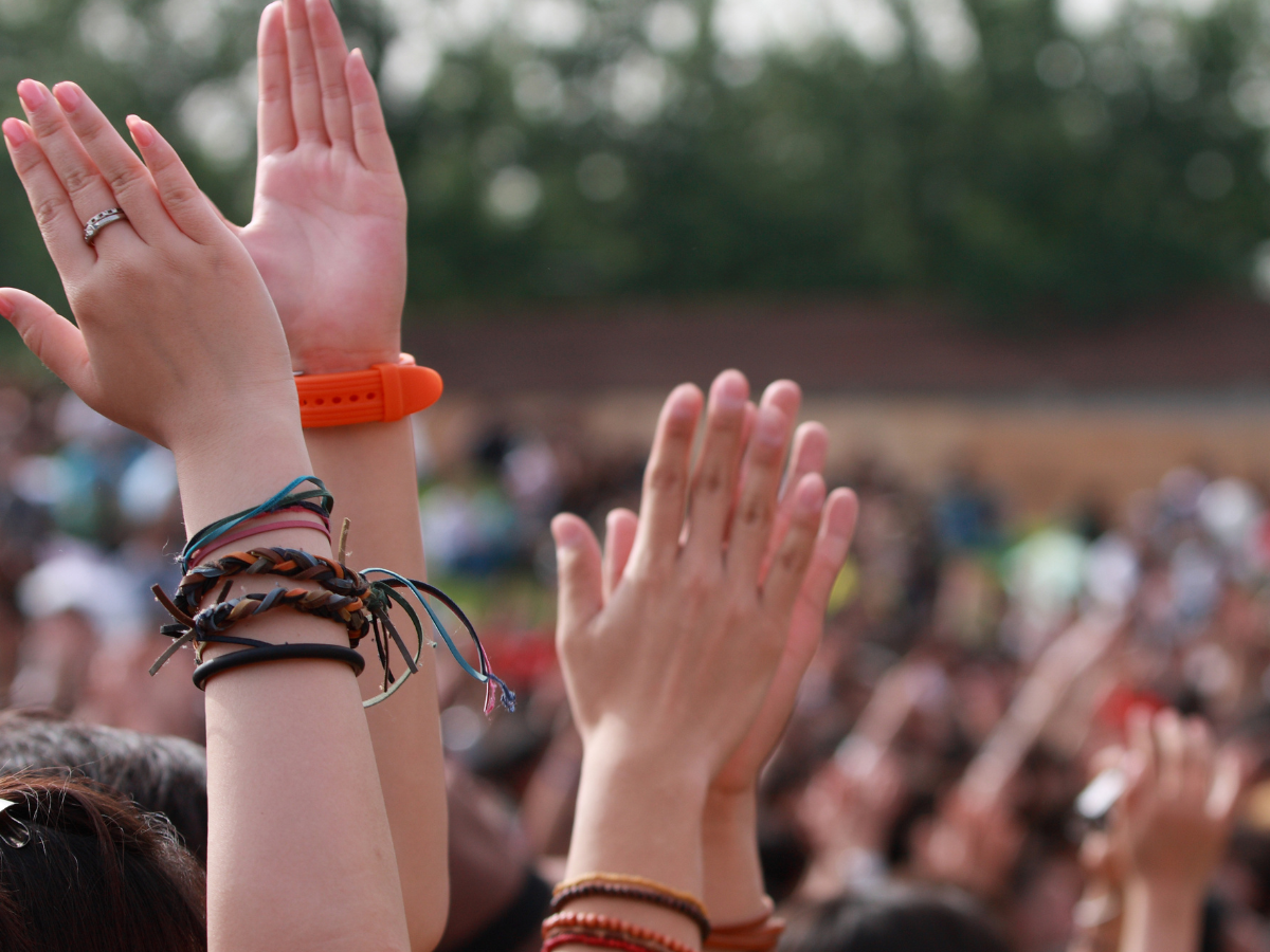 Hands clapping in a festival crowd, symbolising support and unity inspired by Lewis Capaldi’s mental health message.