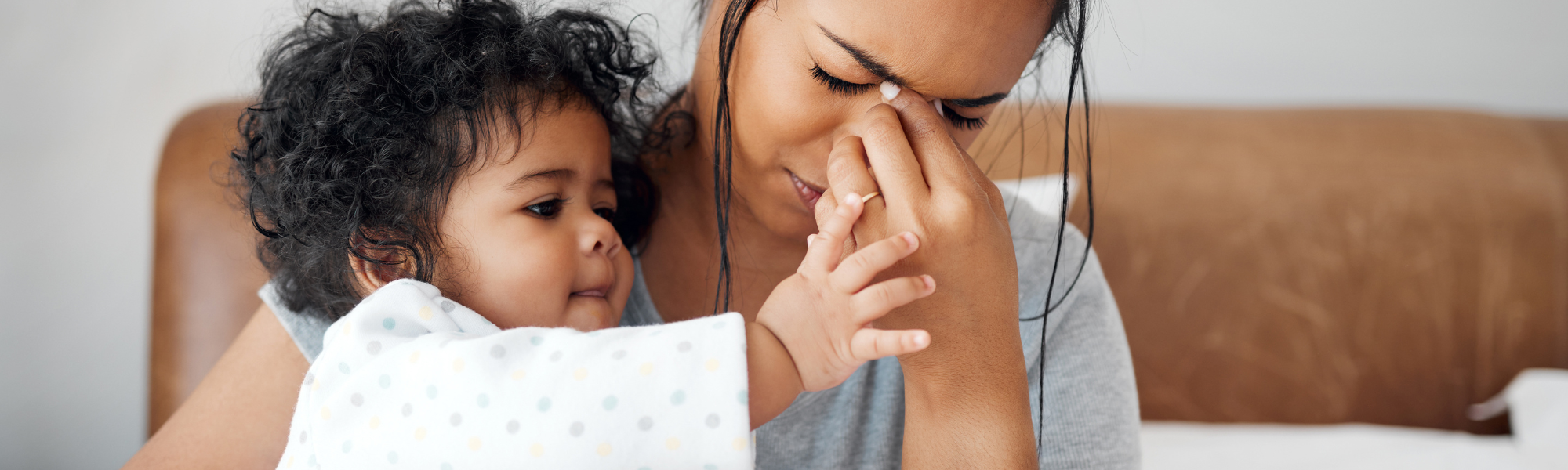Struggling mother experiencing parental burnout while toddler tries to get her attention – The Eaves Counselling and Psychology