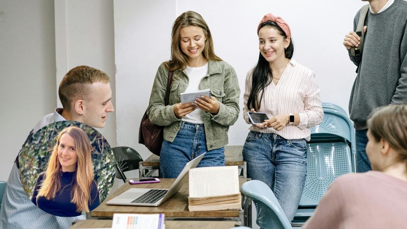 Group of millennials sitting and standing around a table, chatting and laughing casually, enjoying a relaxed social moment