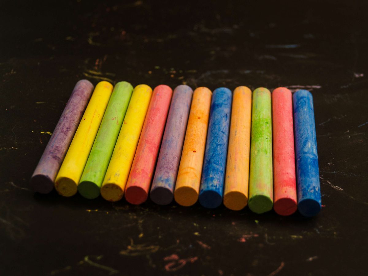 Coloured chalk arranged neatly in a precise pattern on a blackboard, representing order, perfectionism, and obsessive compulsive disorder (OCD).