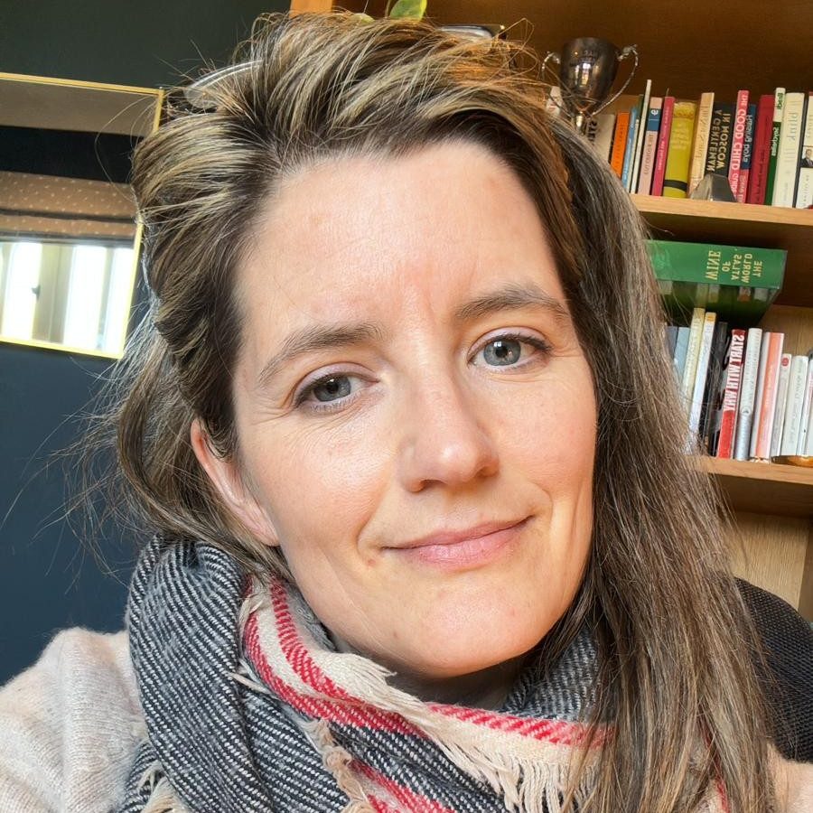 Portrait of a therapist offering integrative relational counselling for adults, smiling warmly in a calm, casual setting.