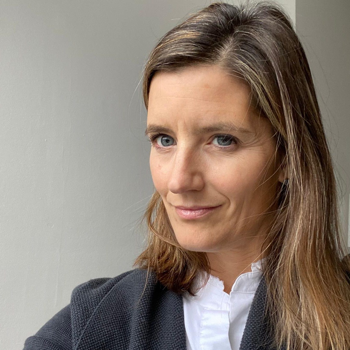 Therapist [name] smiling warmly in a professional portrait, offering integrative relational counselling.