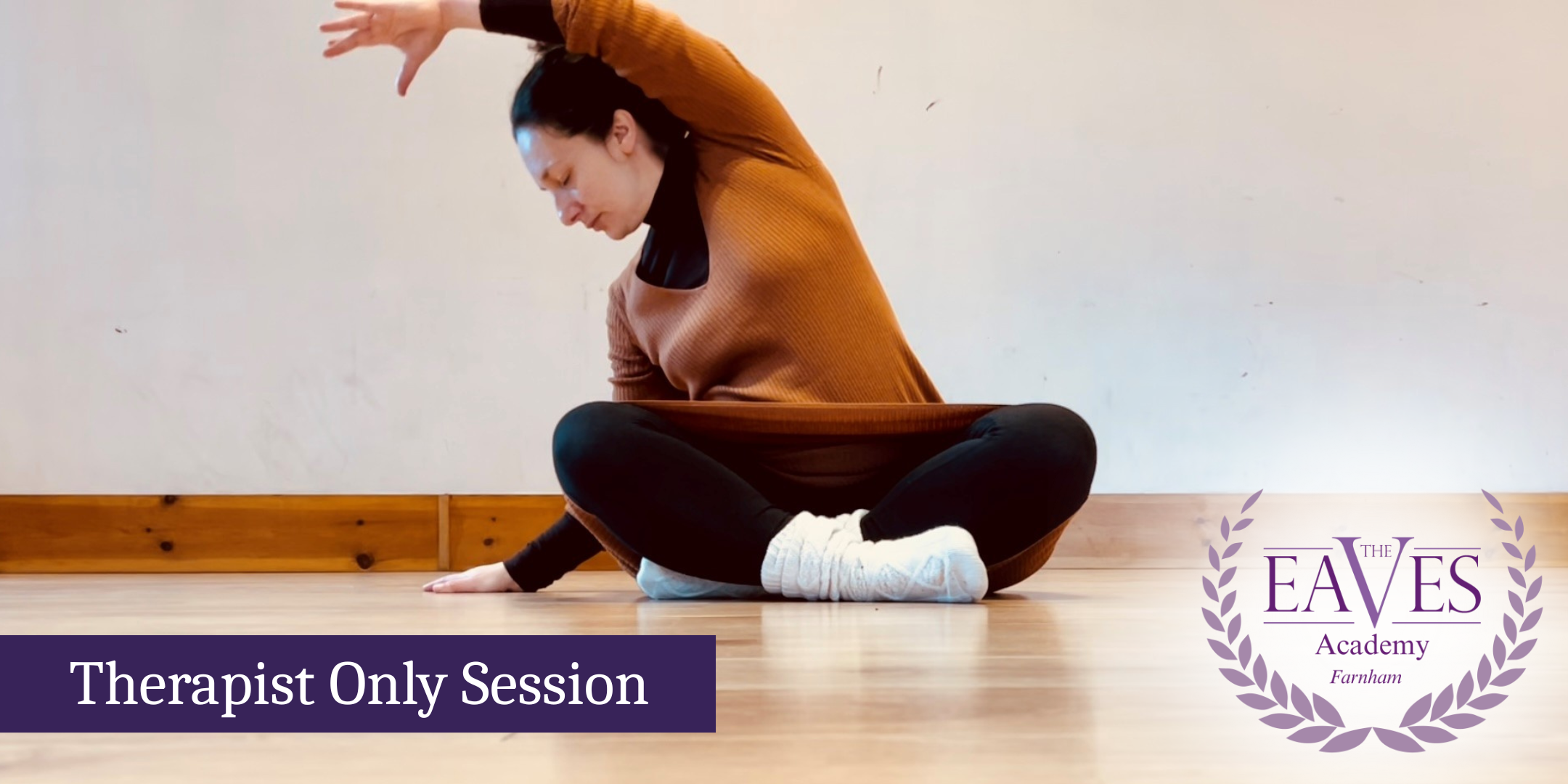 Woman sitting cross-legged in a calm yoga pose with The Eaves Academy Farnham logo in the corner.