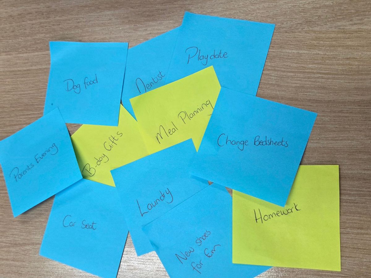 background covered with sticky notes showing multiple to-do tasks, symbolising mental load and overwhelm.