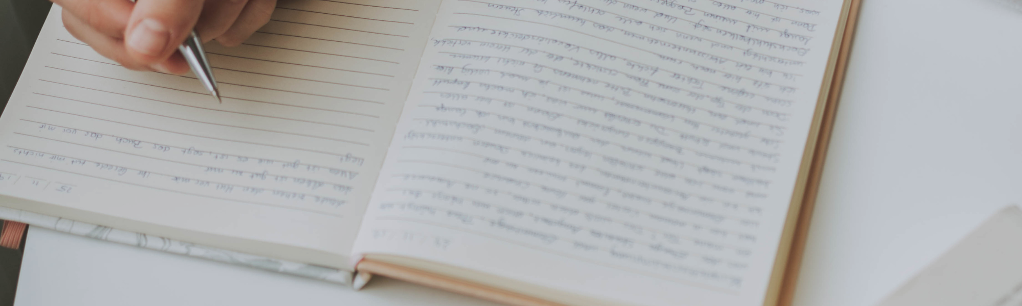 Woman writing notes in a notebook during counselling supervision session.