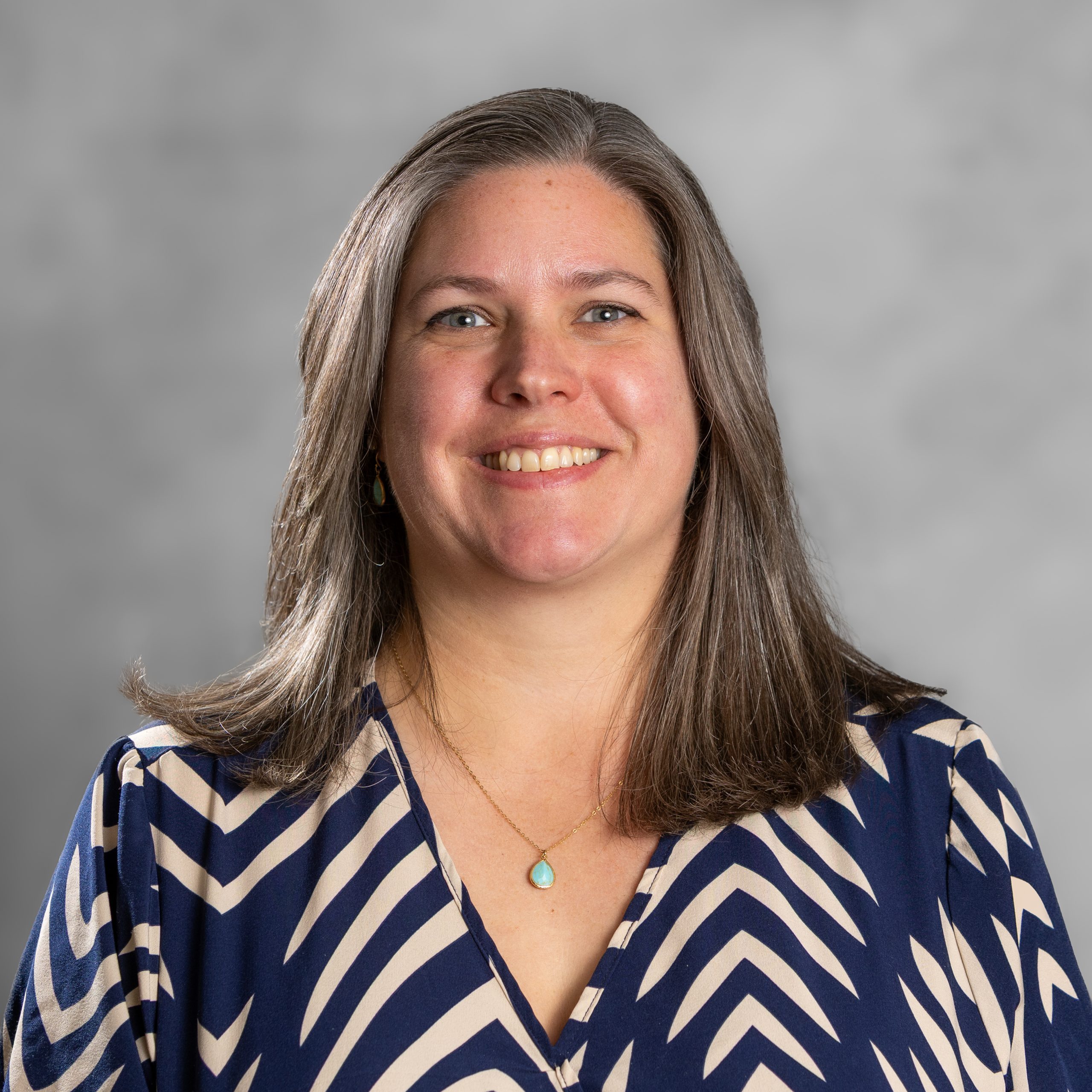 Profile photo of Felicity Clark-Wells, an integrative counsellor offering therapy to adults and couples for anxiety, depression and relationship issues. She has long brown hair and is wearing a blue blouse with patterns on.