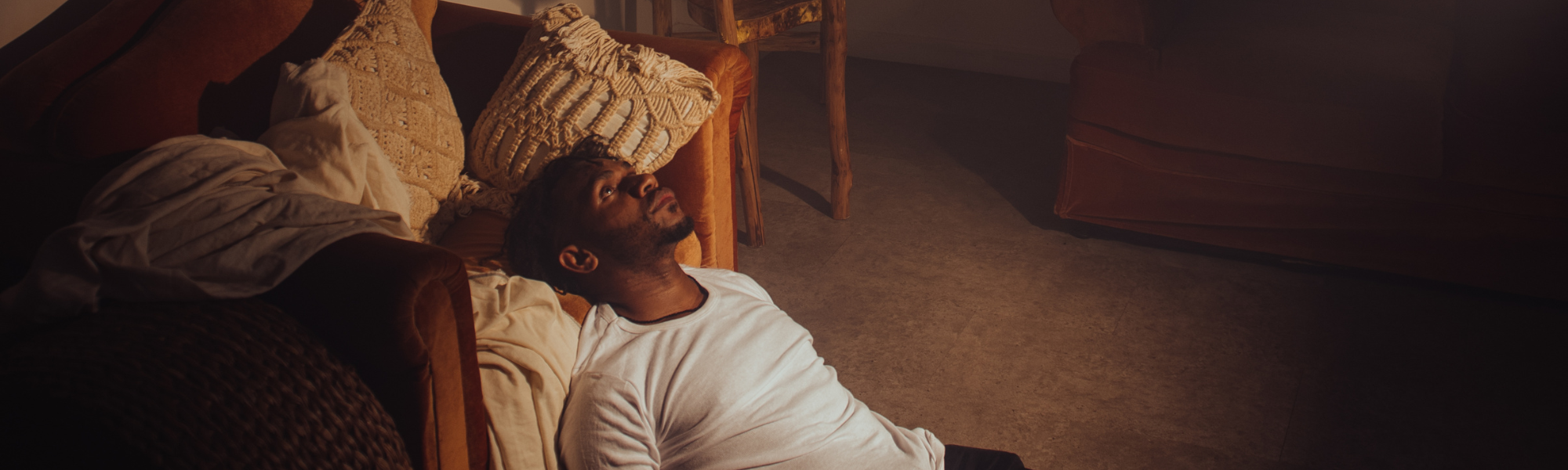 Worried man lying on living room floor, representing Sunday night anxiety