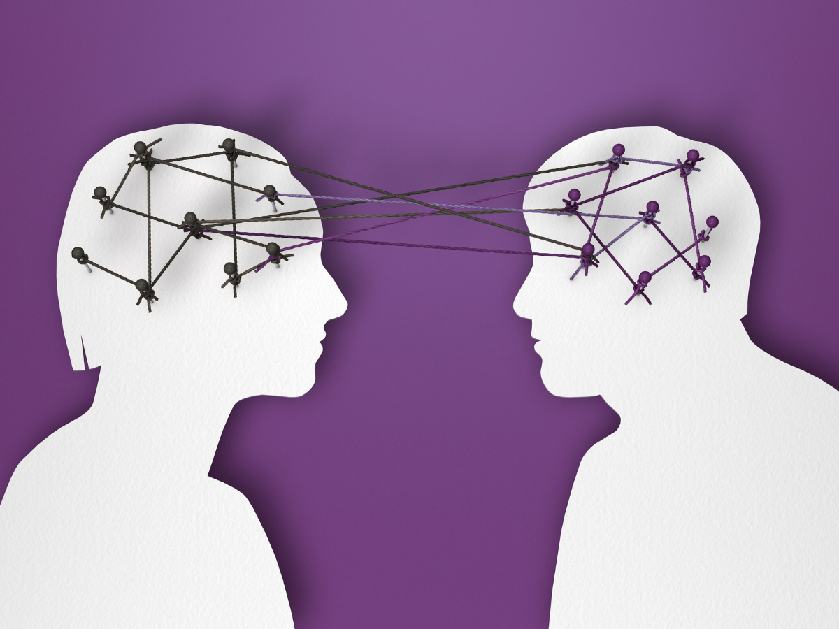 White silhouettes of a man and woman facing each other on a purple background, with pins and string connecting their heads to represent emotional connection.