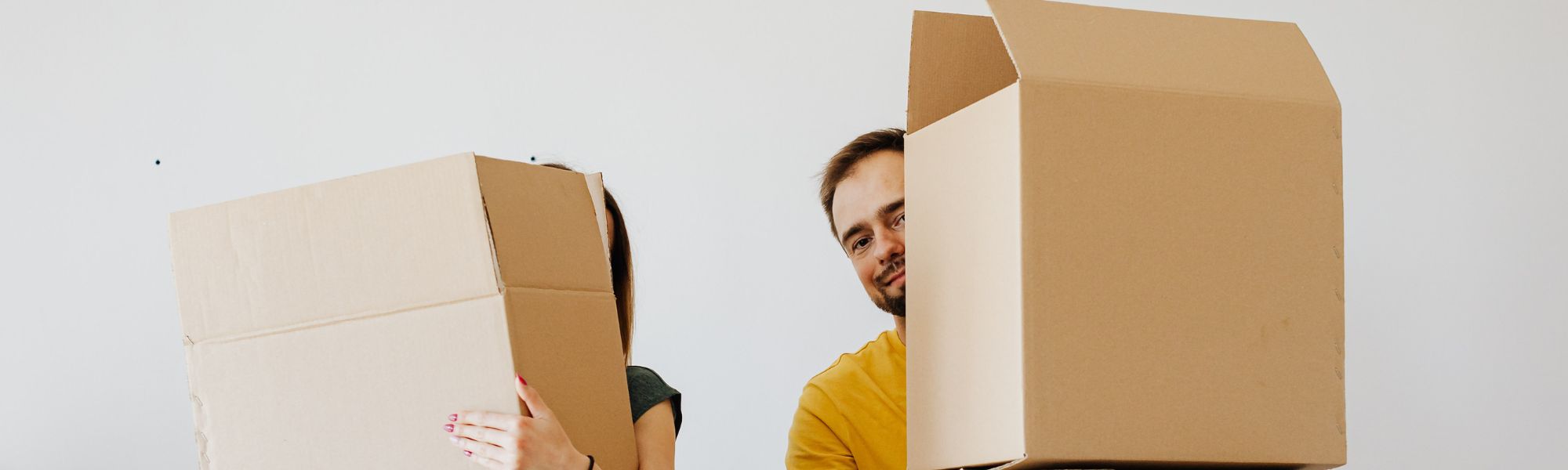 Man and woman carrying boxes while moving house, representing life transitions and coping with change