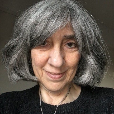 Helen Hadjidimitriadou, is an integrative and trauma-informed therapeutic counsellor, psychotherapist and supervisor working with adults that are neurodivergent. She has short grey hair and is wearing a black sweater.