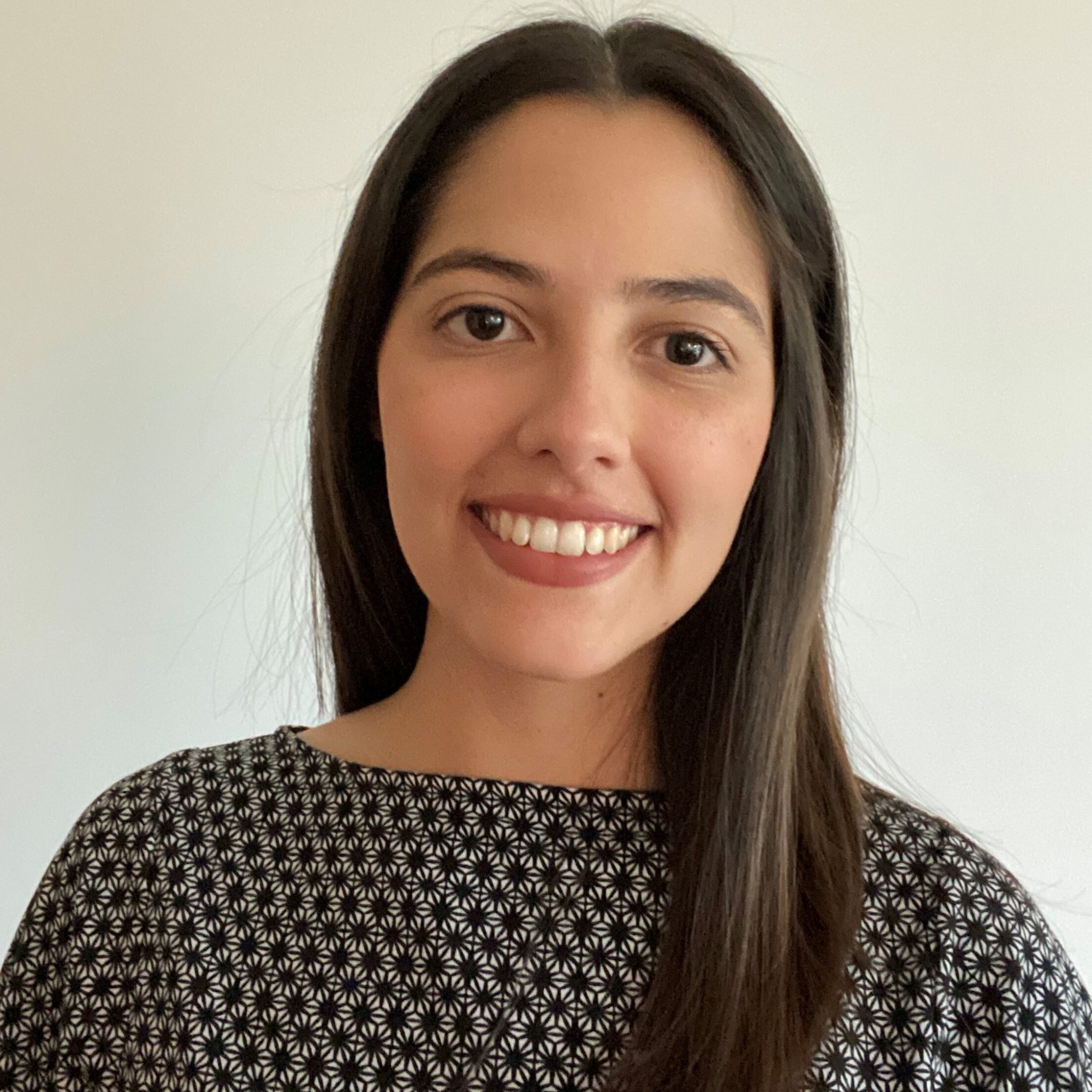 Image of Ana Chacin, a clinical psychologist working with children and adults with neurodevelopmental conditions. She has long dark brown hair and is wearing a black top with patterns on.