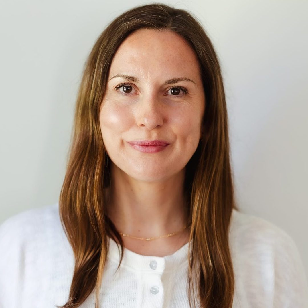 Image of Lally Pearson, an integrative counsellor working with adults experiencing anxiety, difficult family dynamics, overwhelm and low mood. She has long brown hair and is wearing a white cardigan.