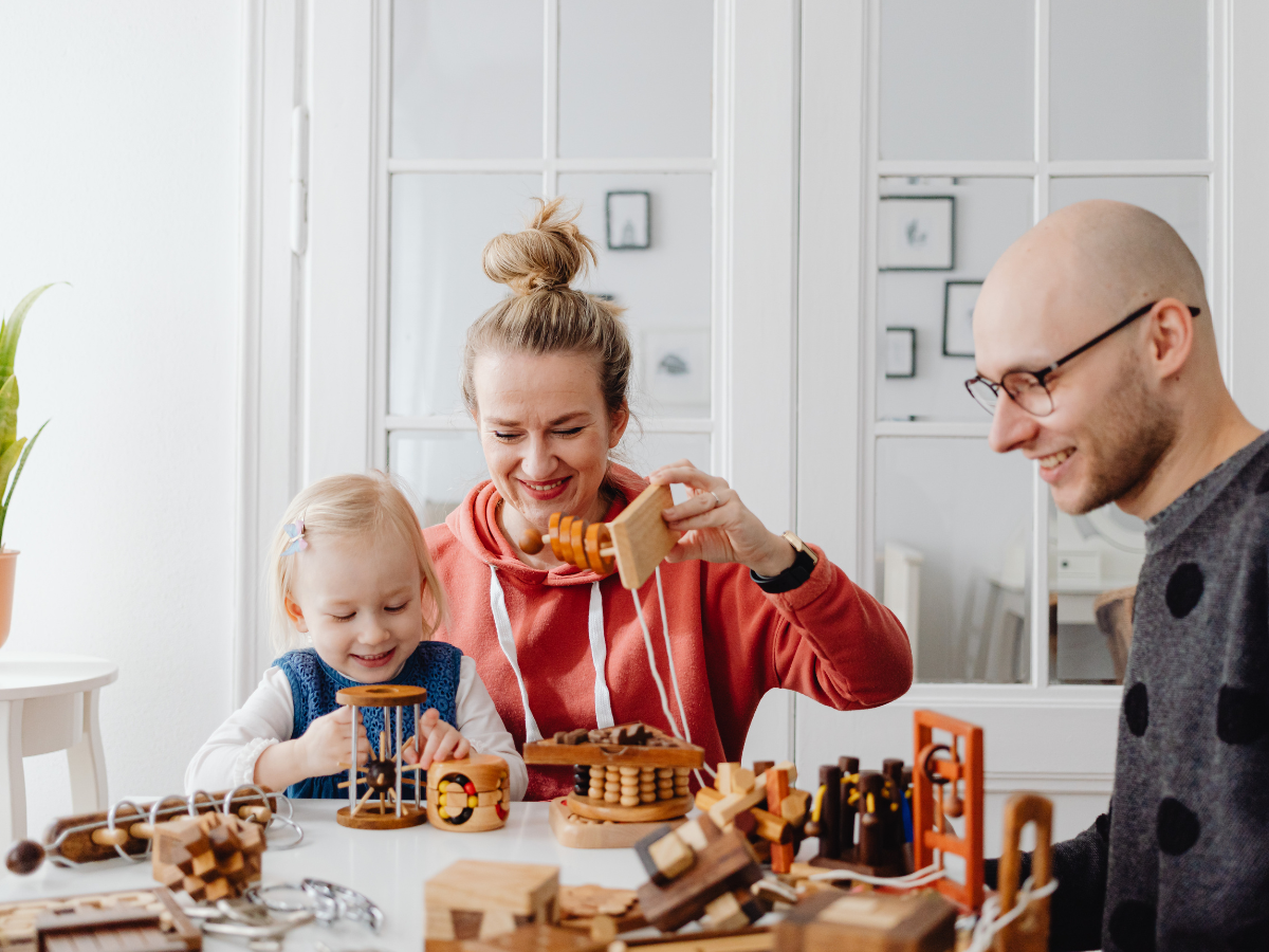 Parents and child playing together, illustrating how early relationships and childhood experiences can shape emotional development and wellbeing.