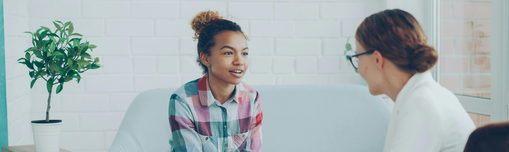 Therapist talking with a teenage girl during a counselling session, providing emotional support and mental health guidance.