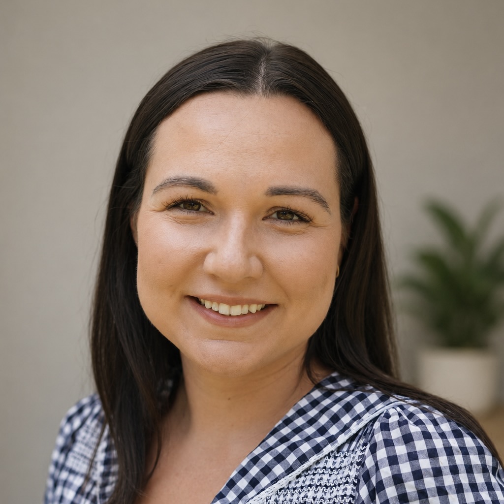 Image of Alice Coulson, a clinical psychologist with dark brown hair and a blue chequered shirt supporting adults experiencing terminal illness and bereavement and loss.