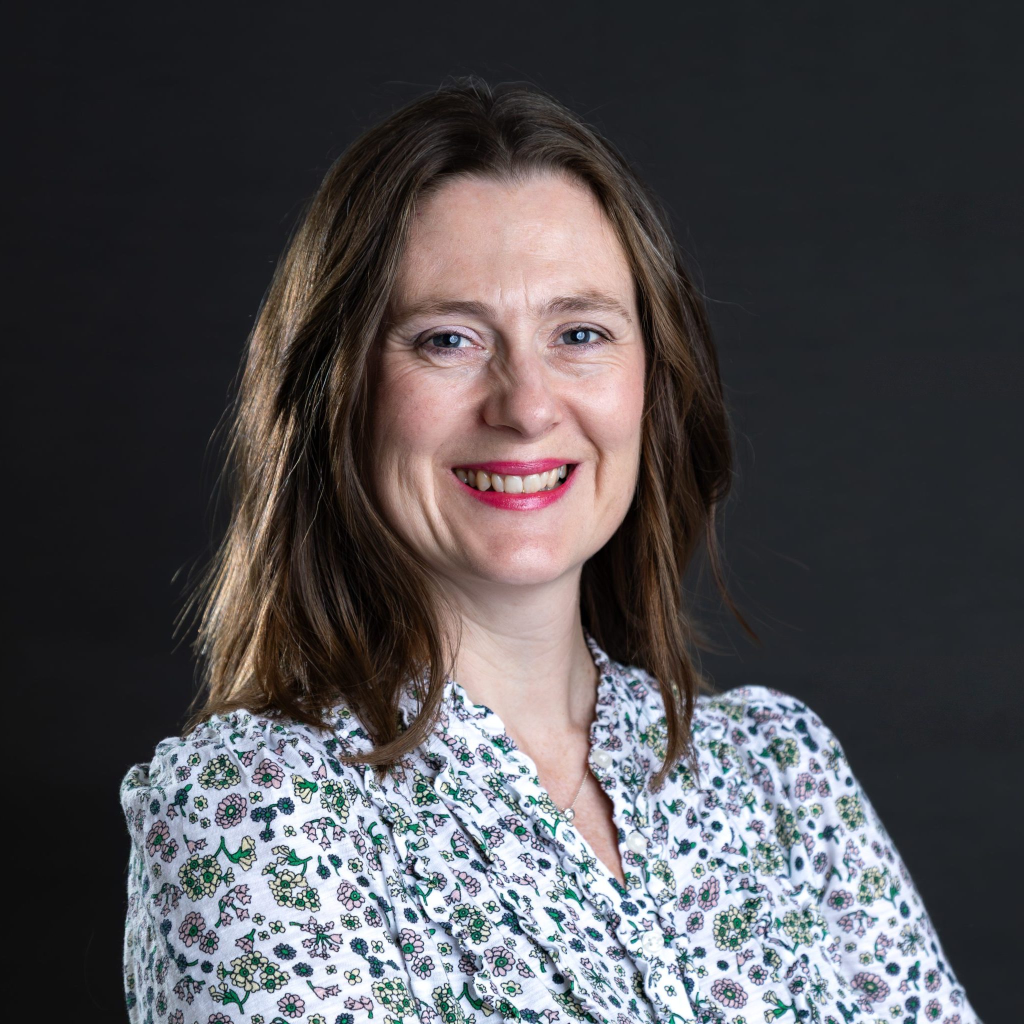 Alison Mann, integrative counsellor with short brown hair and a floral shirt, supporting adults with trauma and life transitions