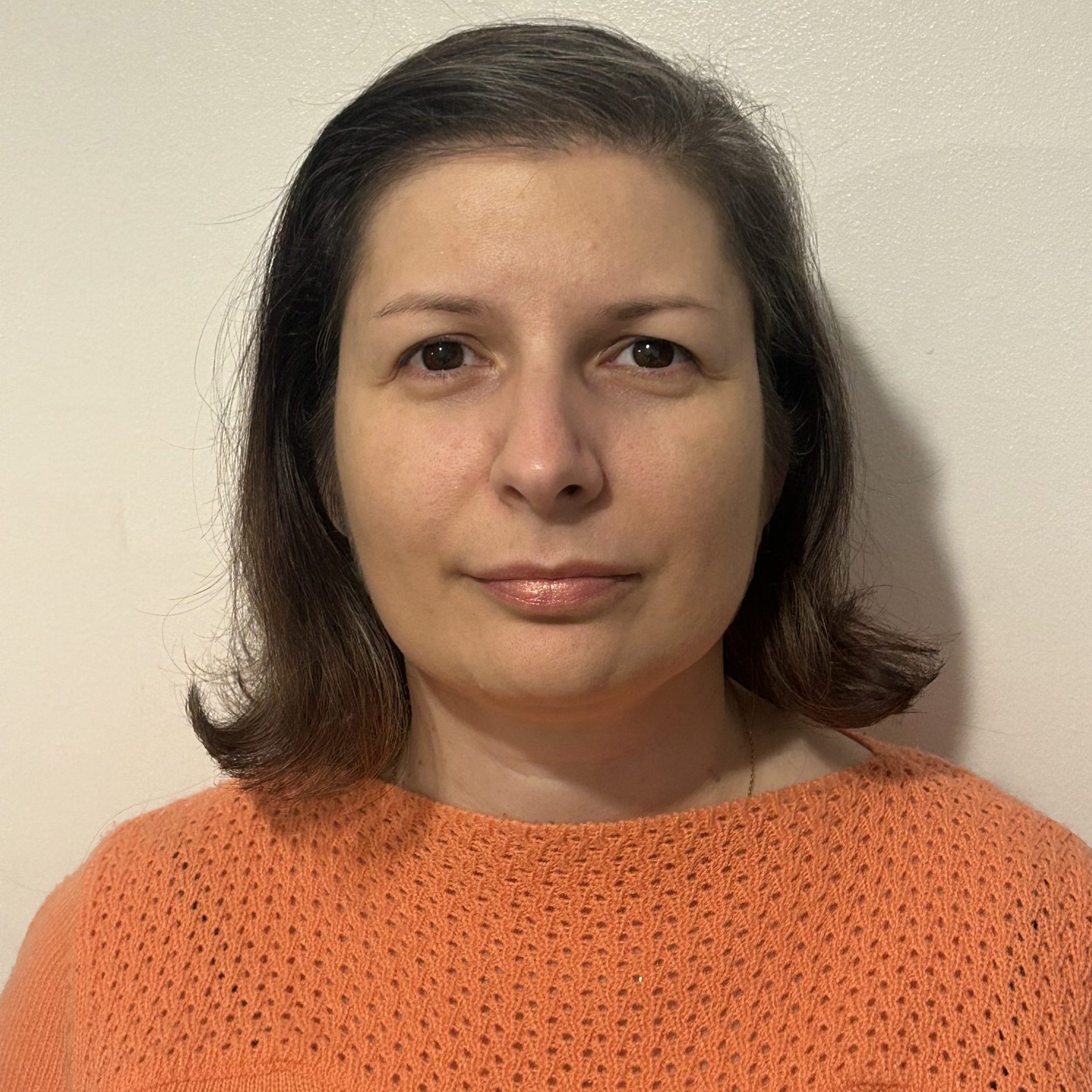Image of Beatrice Mistretu, an integrative counsellor with short brown hair and an orange sweater.