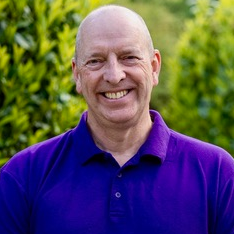 Image of Dave Meller, a bald integrative counsellor wearing a purple shirt.